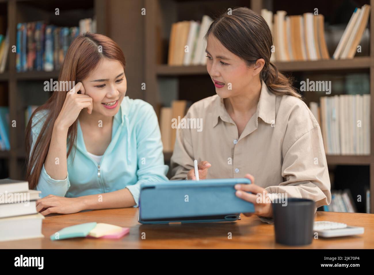 Female Tutoring Math Education concept, Female tutor pointing math quiz on tablet and ...