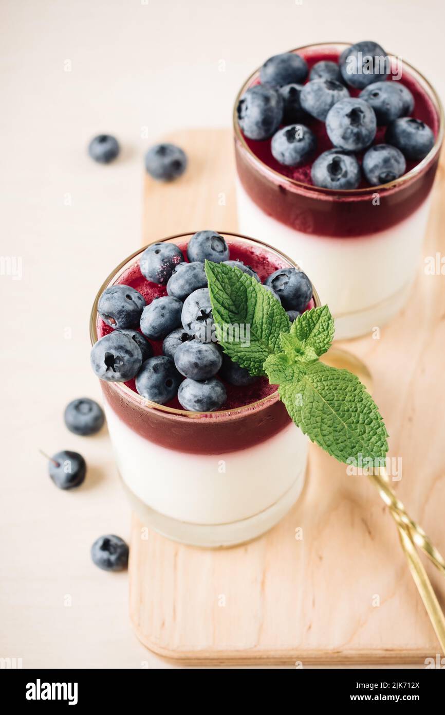 Two glasses of gelatin dessert with blueberries. Yogurt and blueberry