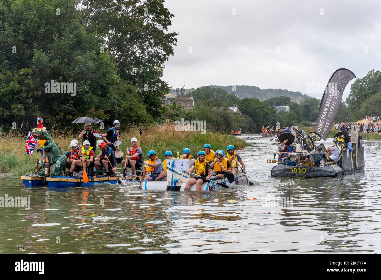 Lewes, UK. 31st July, 2022. Local people in home made rafts take part in the Lewes Raft Race on the River Ouse from Lewes to Newhaven. The Raft Race is an annual event organised by Lewes Round Table in aid of local charities. Traditionally, spectators line up on the riverbank and throw eggs and flour at the rafts with the people on the rafts protecting themselves with home made shields. Credit: Grant Rooney/Alamy Live News Stock Photo