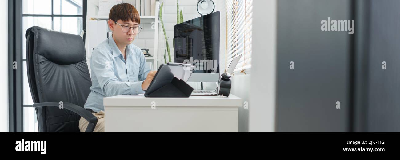 Software development concept, Male programmer point data on tablet to checking website programming. Stock Photo