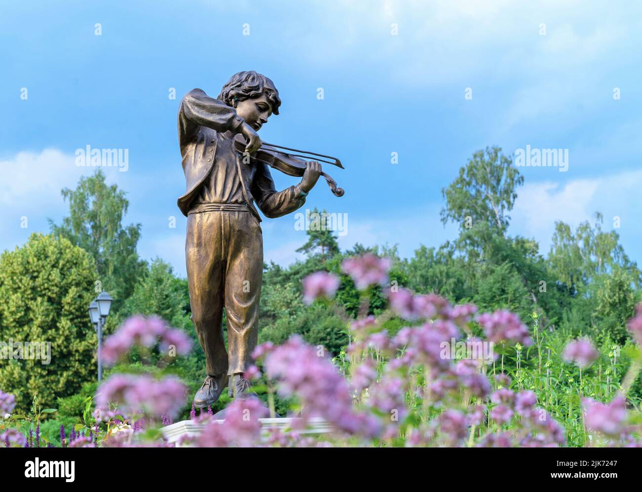 MOSCOW, RUSSIA - July 06, 2022: Bronze sculpture 'Boy playing the violin' in the summer garden. Stock Photo