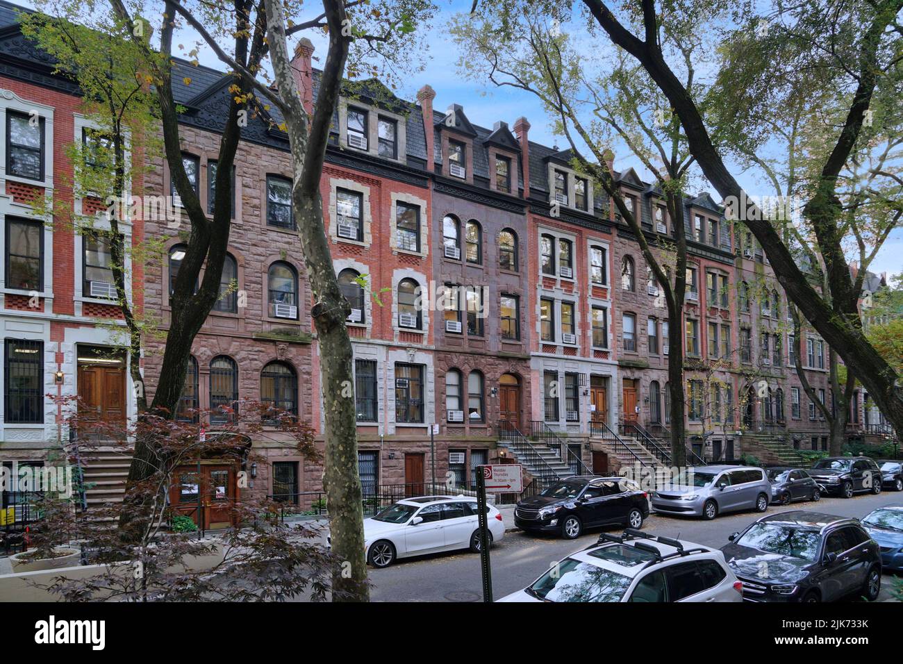 Residential street in New York with long row of old brownstone townhouses Stock Photo