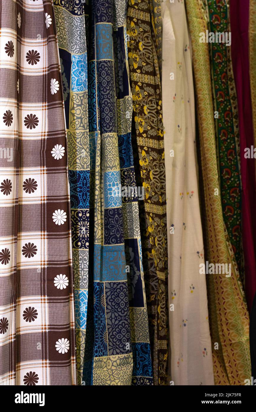 there are various fabrics hanging on the market for sale Stock Photo