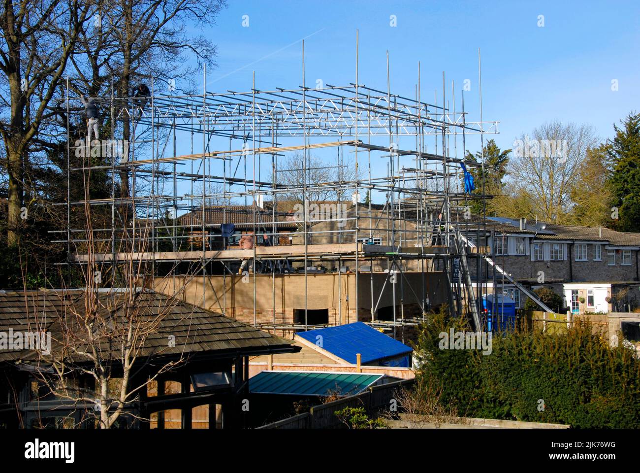 Erecting scaffolding above a new house being built to provide support for a temporary covering as protection against possible inclement weather Stock Photo