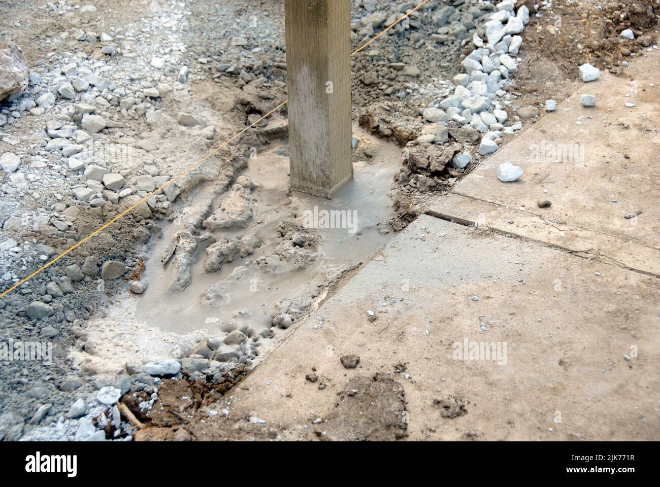Wooden fence post set in quickdrying cement before adding the fence