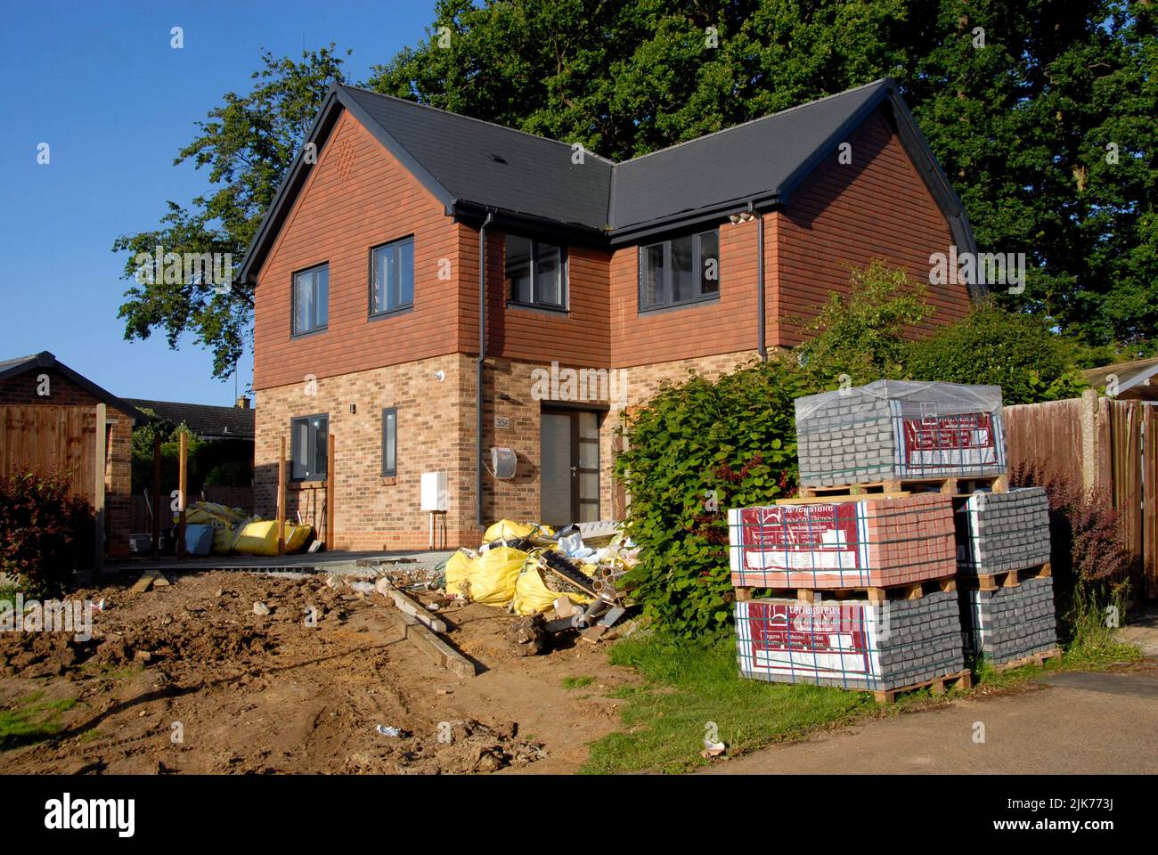 Newly-built house, largely completed but with paving slabs still to be installed and some rubbish for disposal Stock Photo