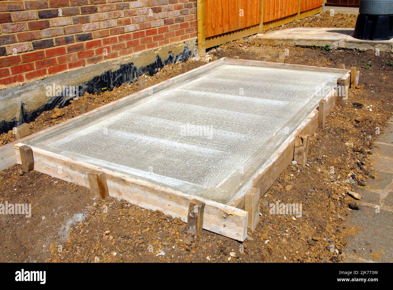 Concrete base for new shed with shuttering in place showing ridged centre and smooth border Stock Photo
