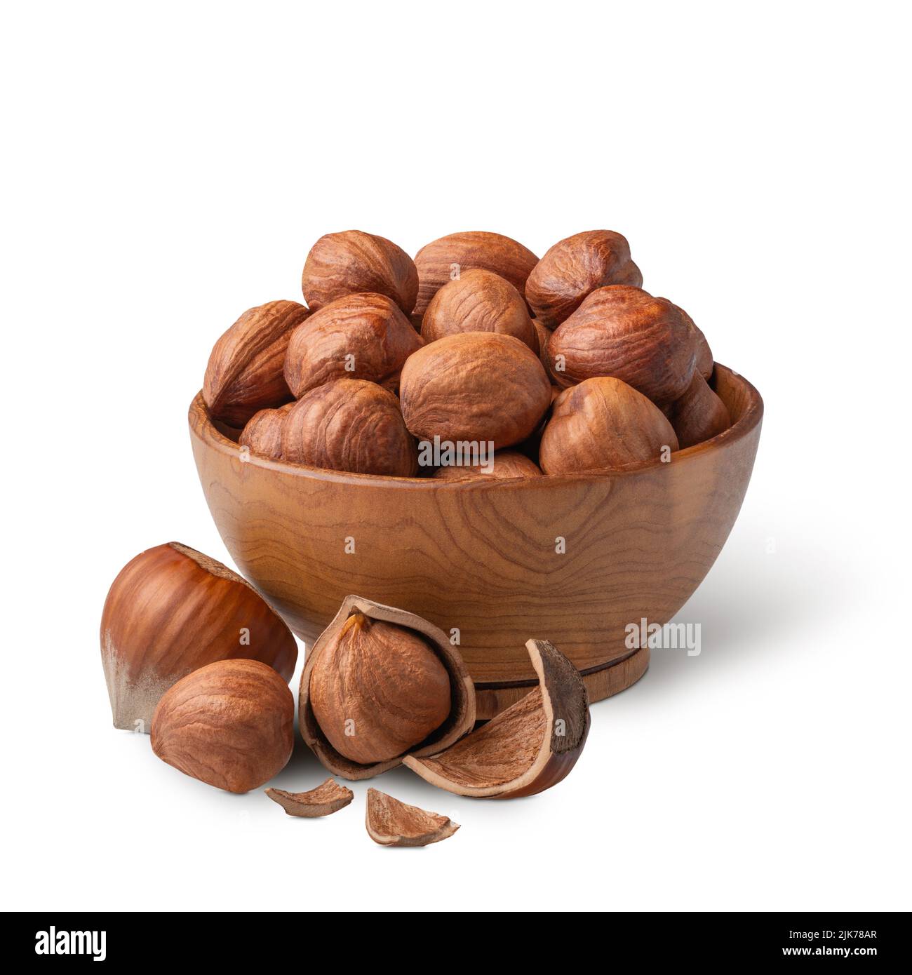 Bowl of hazelnuts with green leaves isolated on white. Deep focus Stock Photo