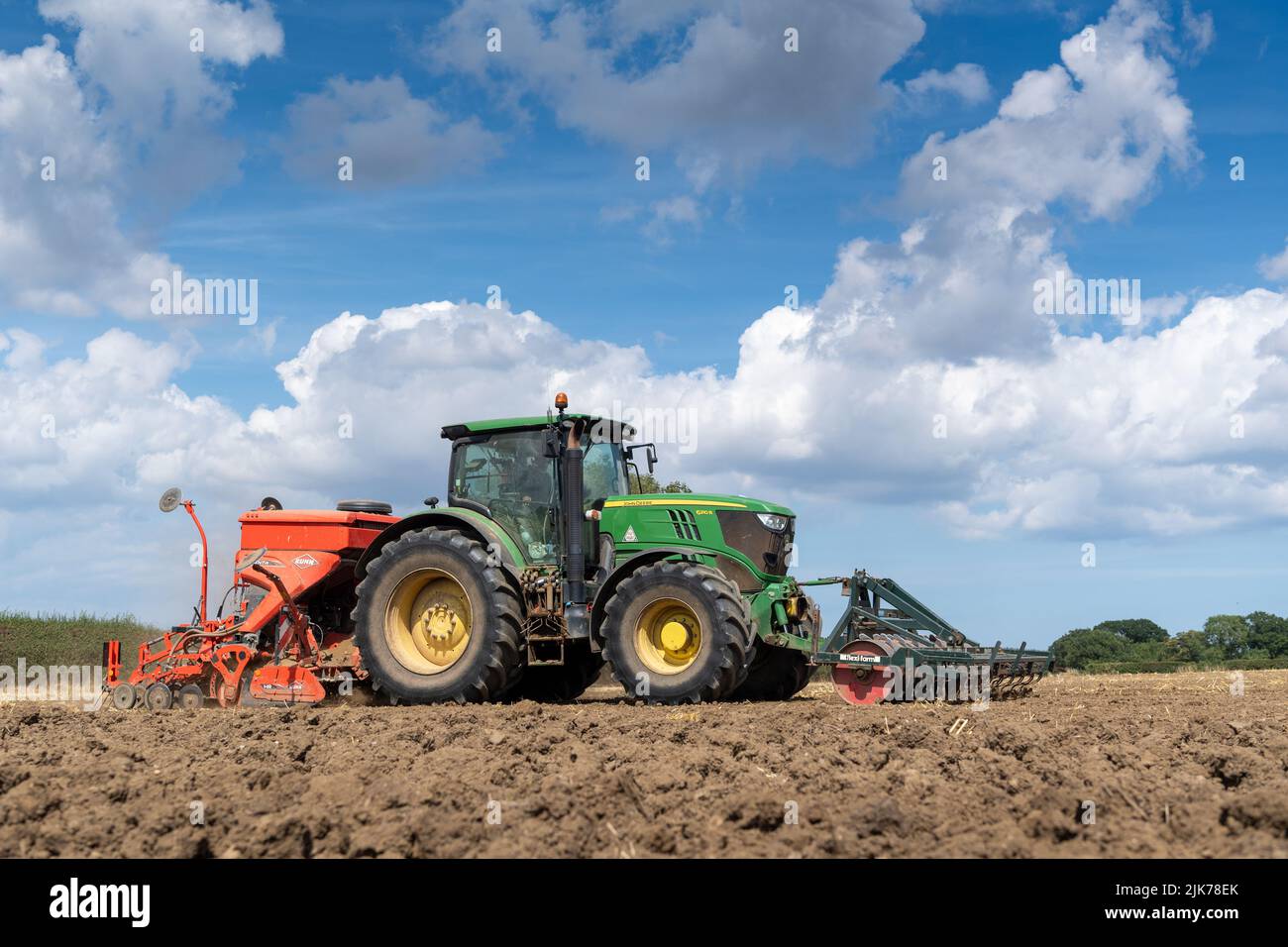 John Deere with a Kuhn Venta seed drill on, planting seed on a newly cultivated seed bed. North Yorkshire, UK. Stock Photo