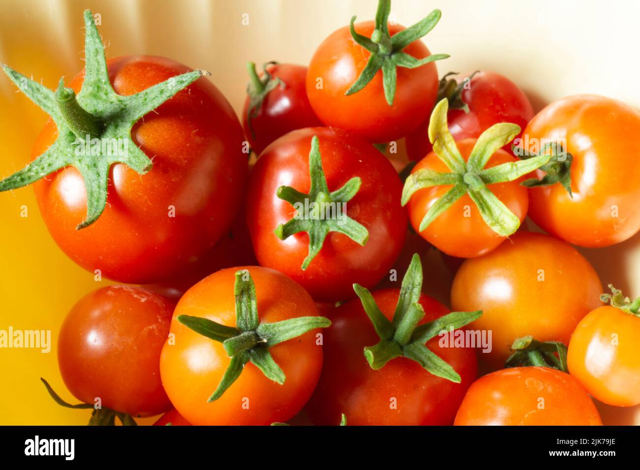 Ripe tomatoes on the table in a plate. Bright natural background of products Stock Photo