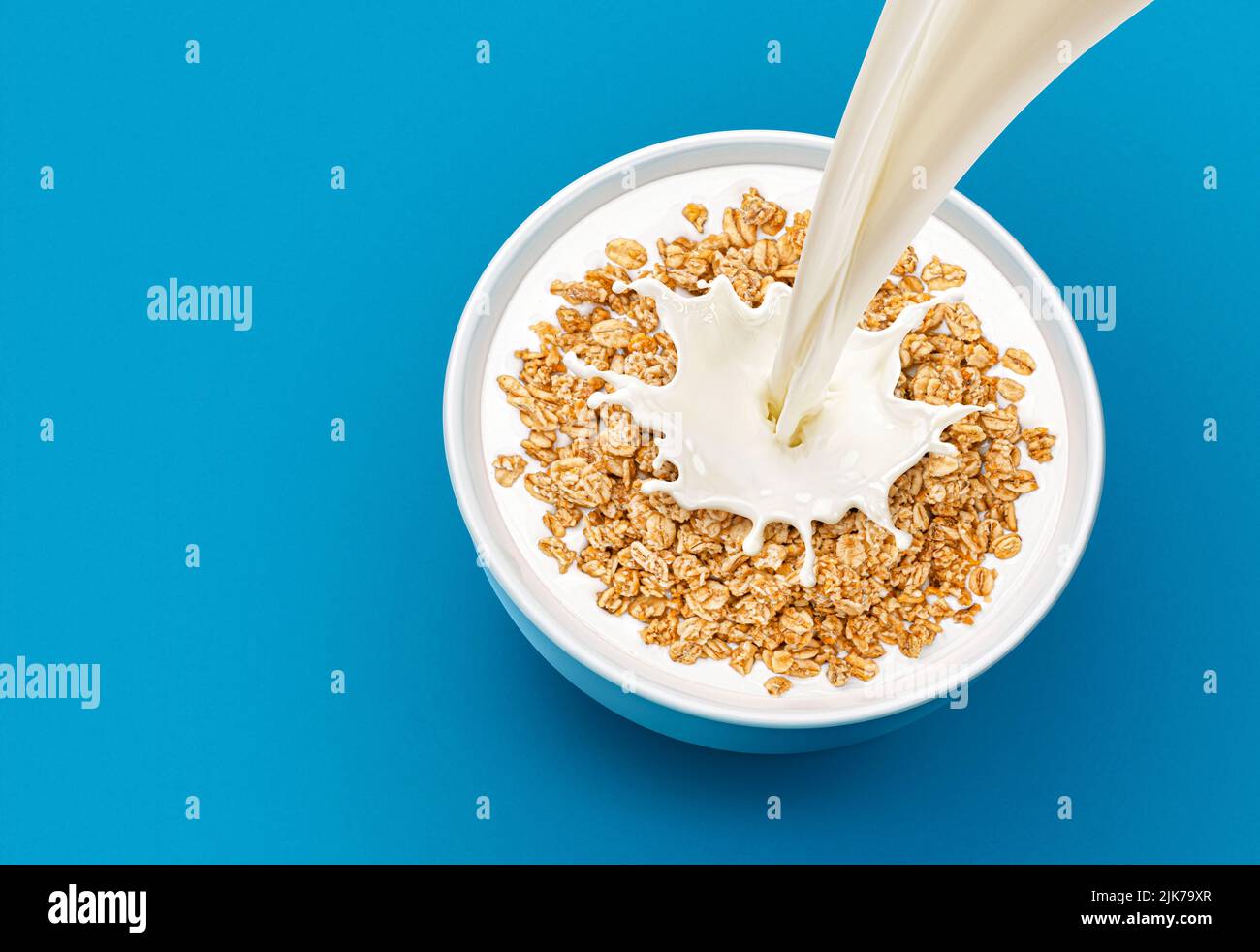 Oat granola with milk isolated on blue background, top view Stock Photo