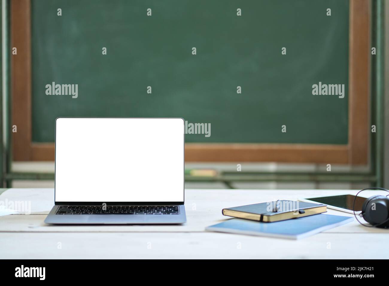 Mock up laptop screen on teacher desk at school background. Online learning Stock Photo