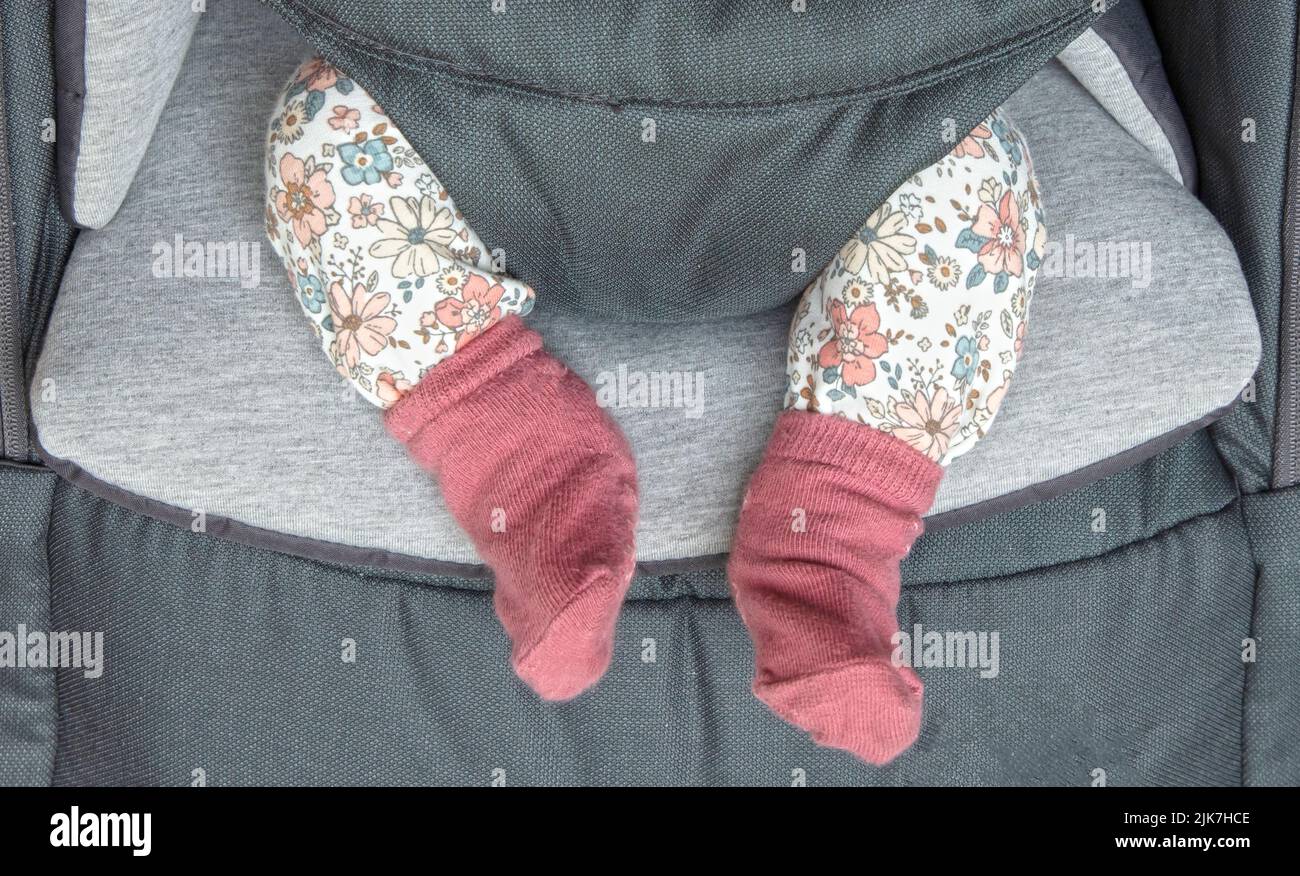 Legs of a newborn baby girl in confortable seat Stock Photo