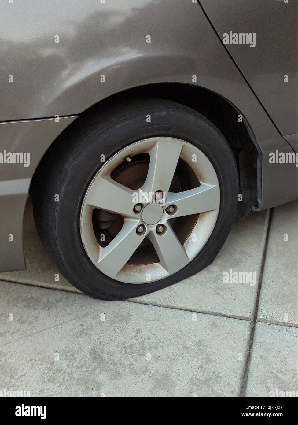 Flat tire on a car parked in driveway Stock Photo Alamy