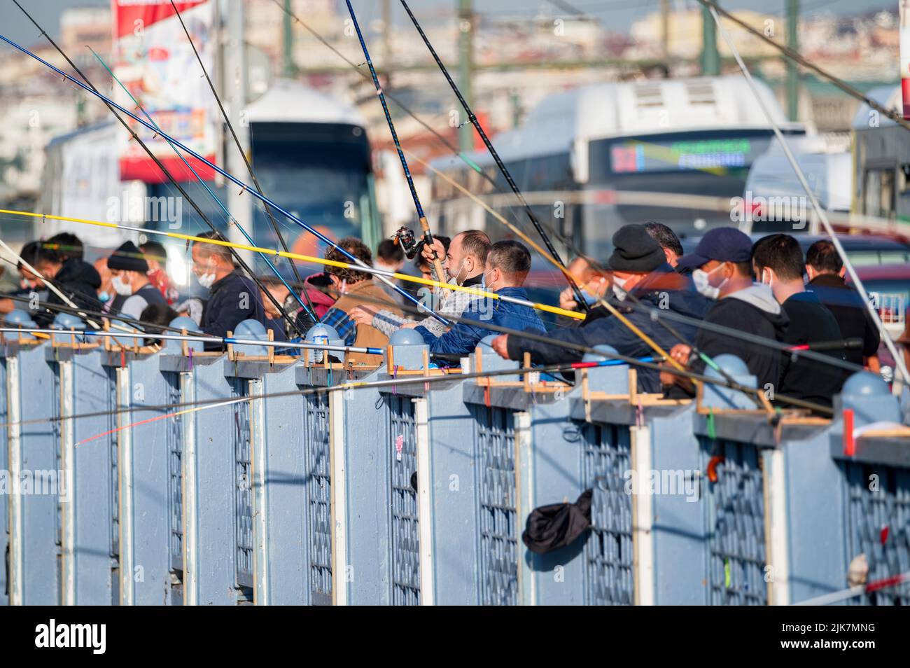 ISTANBUL, TURKEY - 9 DECEMBER 2020: People fish from the Galata bridge in Istanbul. The bridge is well known for rod fishing at sunset. Stock Photo