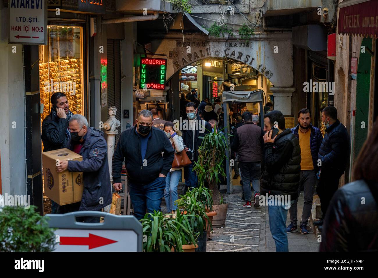 Istanbul, Turkey - 2022: People shopping in the Grand Bazar, handmade lamps, bags and carpets for sale Stock Photo