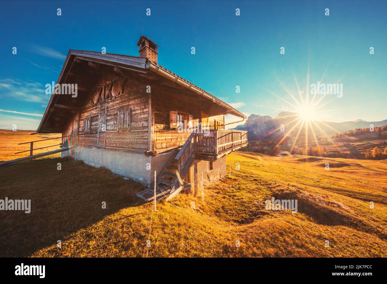 Autumn sunrise scenery with yellow larches and small alpine building and Odle - Geisler mountain group on background. Alpe di Siusi (Seiser Alm), Dolo Stock Photo