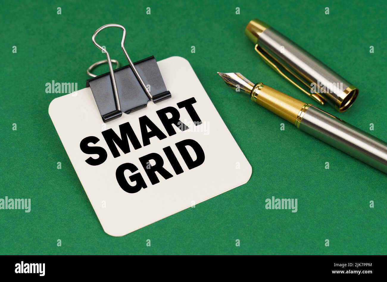 Business and industry concept. On a green surface, a pen and a sheet of paper with the inscription - Smart grid Stock Photo