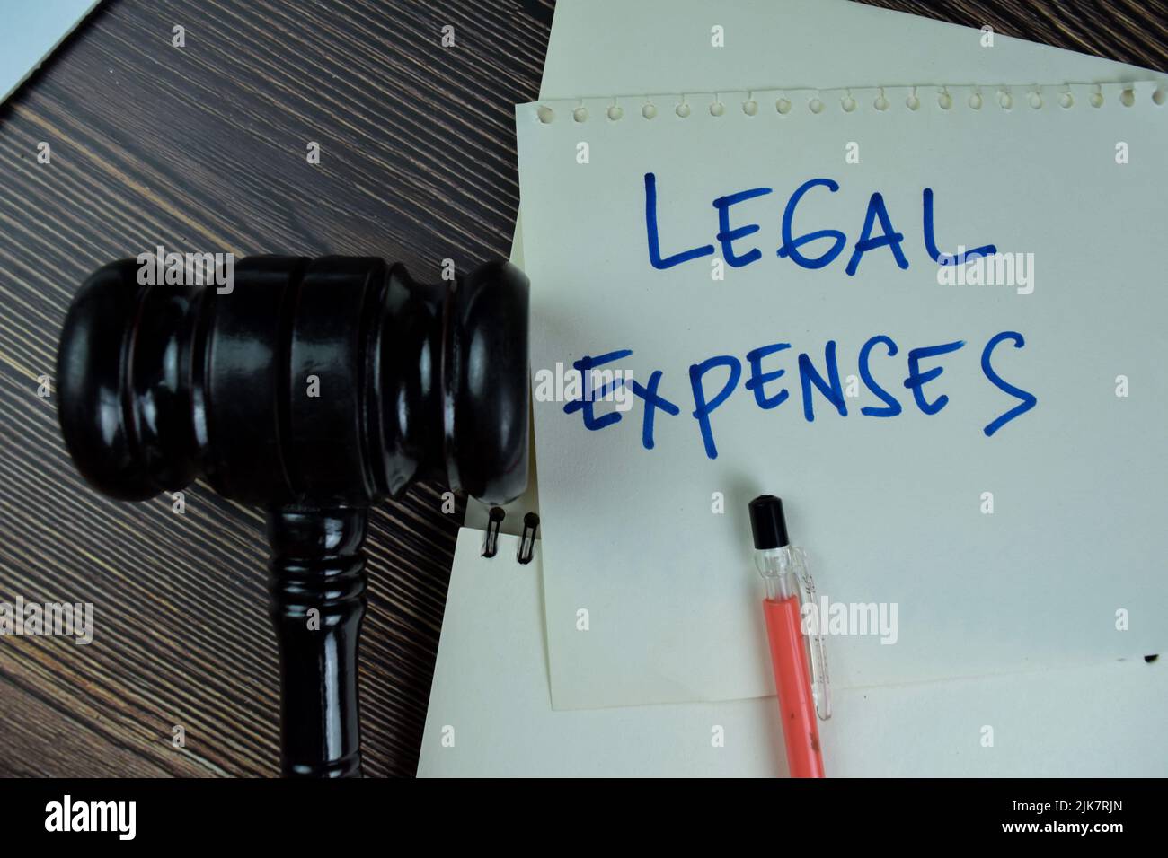 Concept of Legal Expenses write on sticky notes with gavel isolated on Wooden Table. Stock Photo
