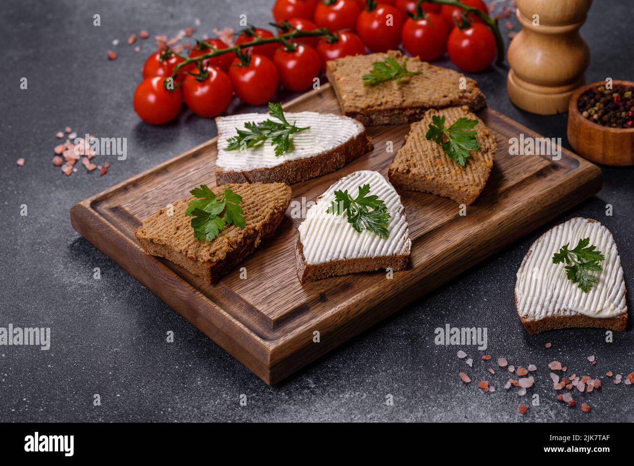 Fresh homemade chicken liver pate on bread over grey background Stock