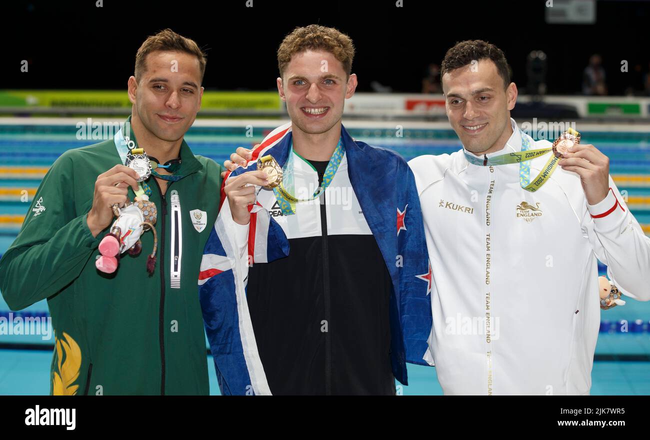 Birmingham, UK. 31st July 2022; Sandwell Aquatics Centre, Birmingham, Midlands, England: Day 3 of the 2022 Commonwealth Games: Lewis Clareburt (NZL) with his Gold Medal and national flag after winning the Men's 200m Butterfly Final alongside Chad Le Clos (RSA) with his Silver Medal and Guy James (ENG) and his Bronze Medal Credit: Action Plus Sports Images/Alamy Live News Stock Photo