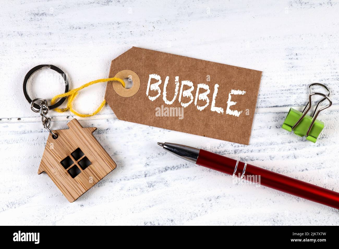 Real estate bubble concept. Cardboard price tag on wooden table. Stock Photo
