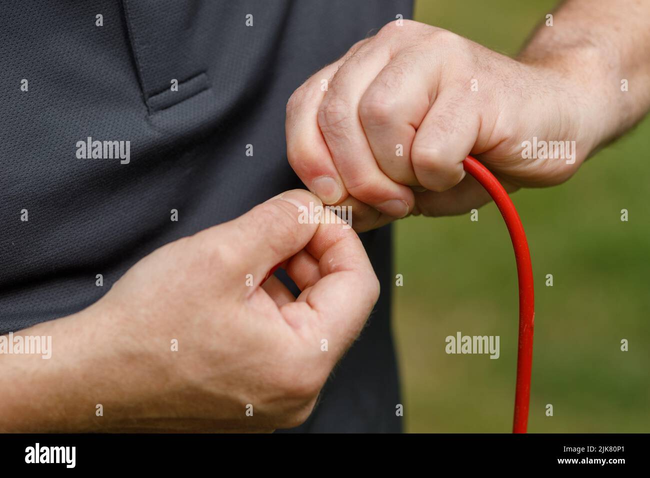 Hands connecting electrical wires together. Male hands and fingers
