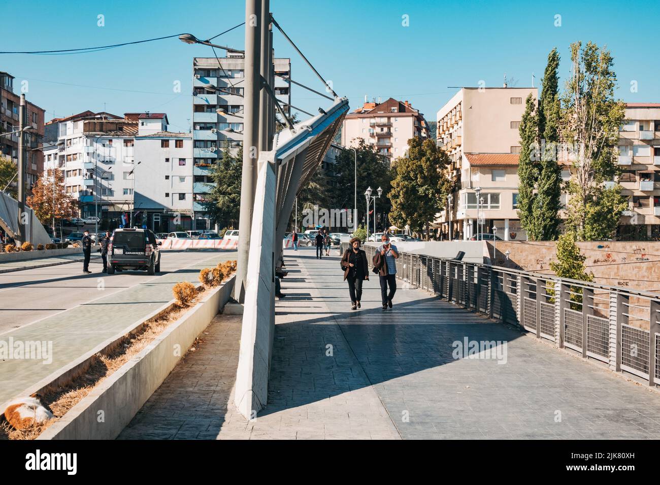 Pedestrians walk across the New Bridge in Mitrovica, Kosovo. The bridge used to be a checkpoint between the city's Serb north and Kosovar south Stock Photo