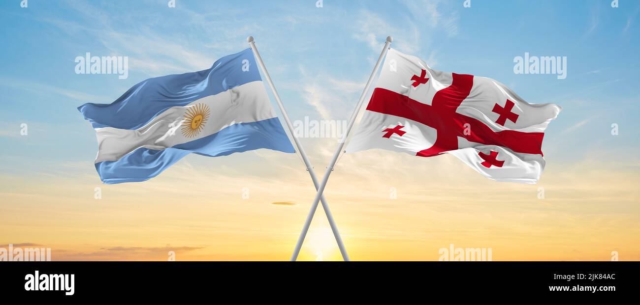 crossed national flags of Argentine and Georgia flag waving in wind at ...