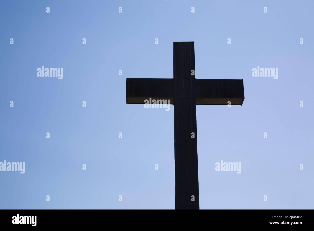 Silhouetted Cross Against A Blue Sky Background Stock Photo Alamy