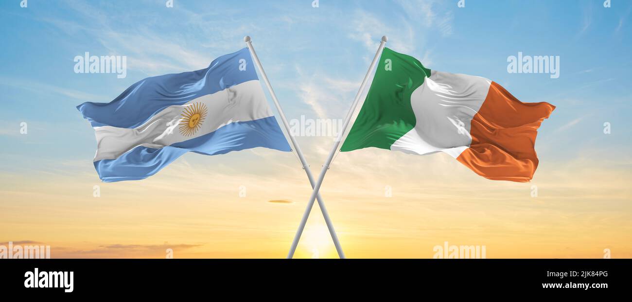crossed national flags of Argentine and Ireland flag waving in wind at ...