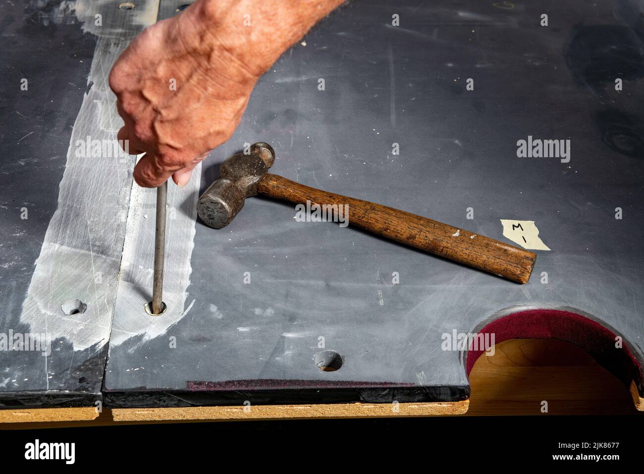 Bare naked pool table slate screwing slate panels in Stock Photo