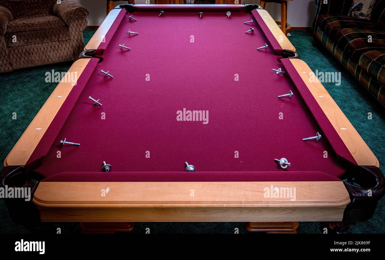 Bolts from pool table rails removed and displayed on the felt Stock Photo