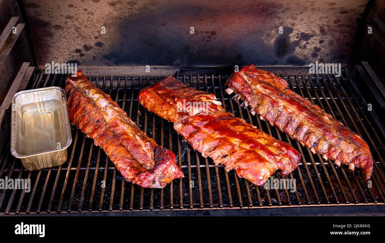 Sauced ribs on a smoker almost ready to eat Stock Photo