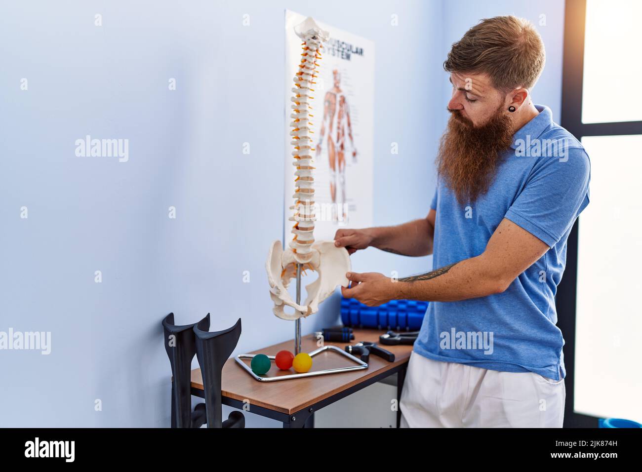 Young redhead man wearing physiotherapist uniform pointing to