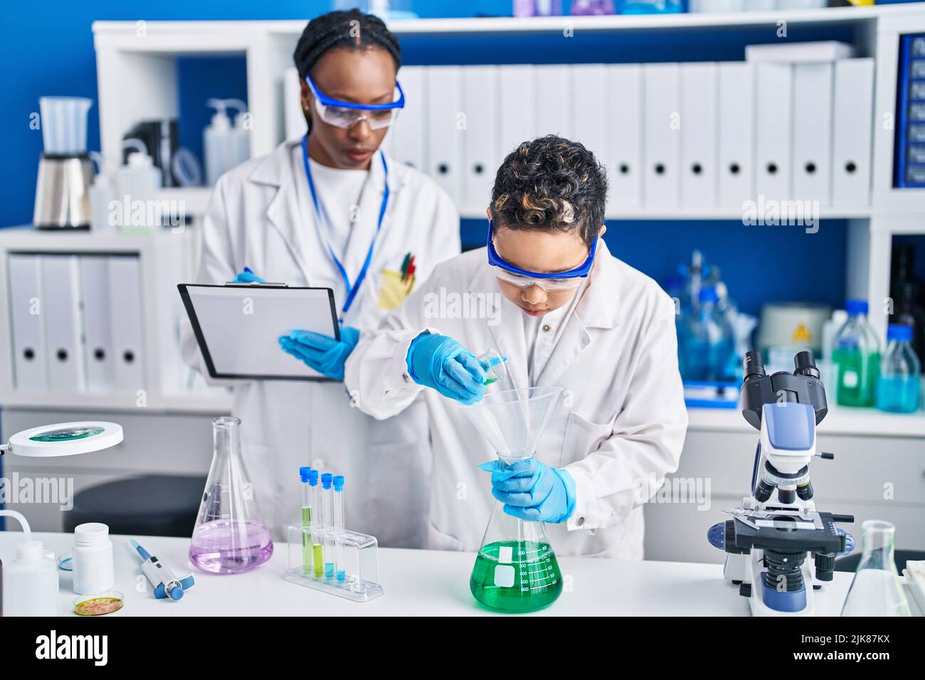 African american mother and son scientists measuring liquid laboratory ...