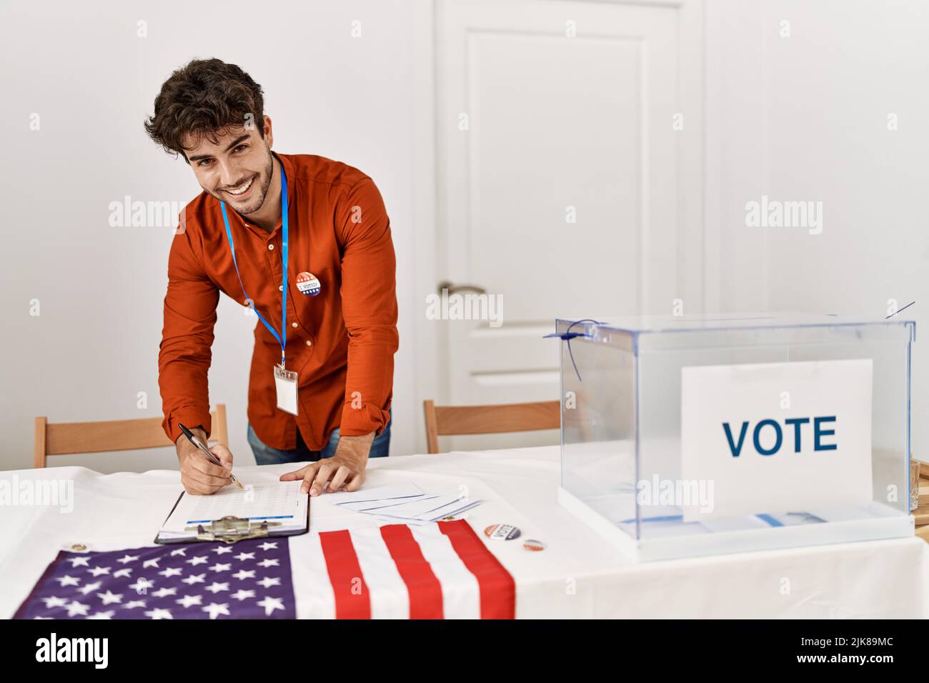 Young hispanic man smiling confident writing on checklist at electoral college Stock Photo