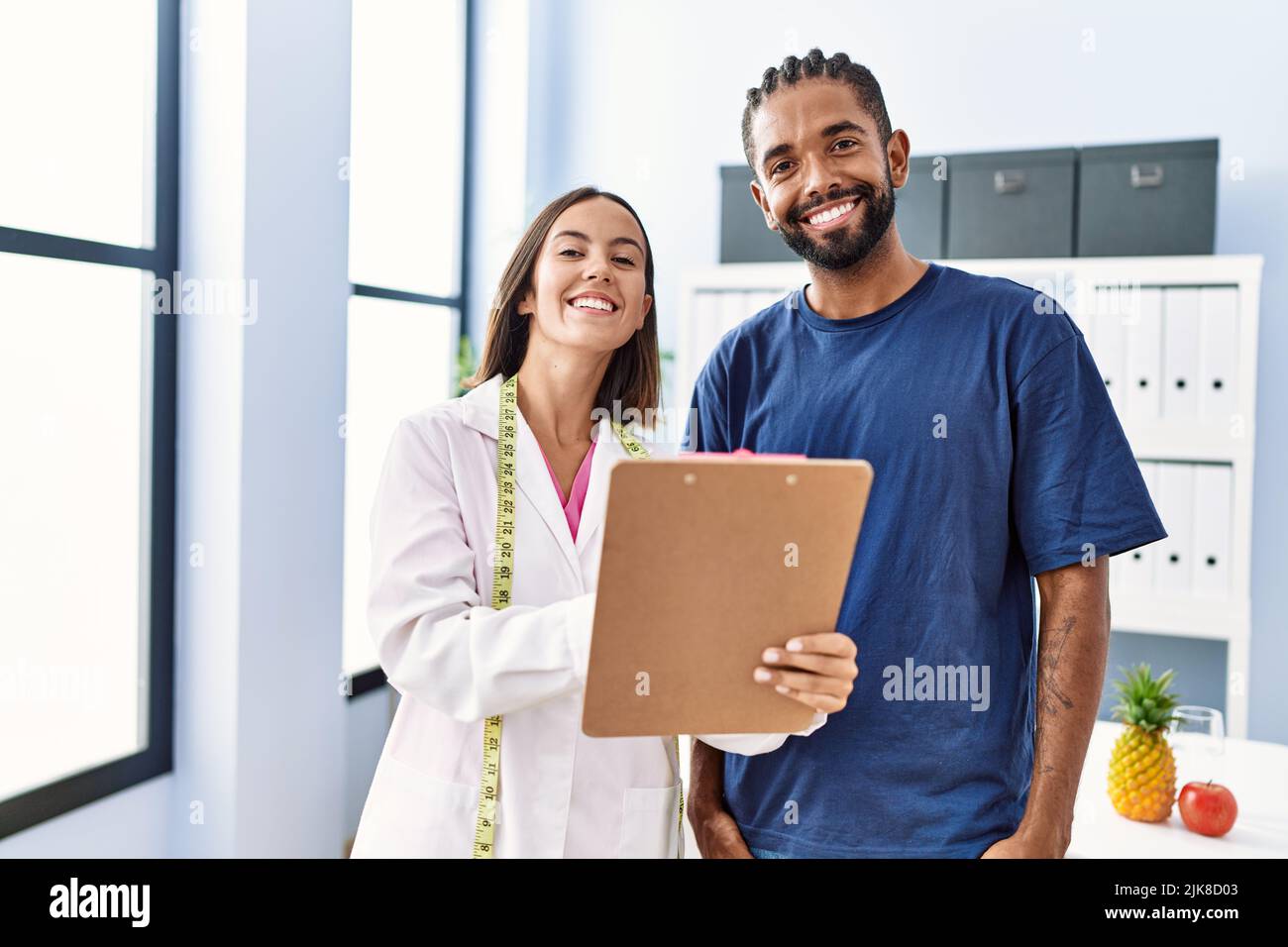 Man and woman wearing nutritionist uniform having nutrition session at