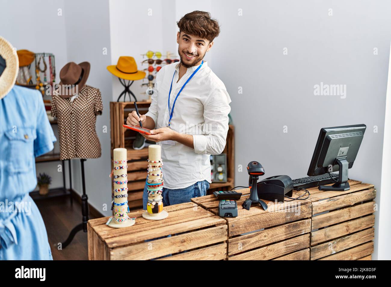 Young arab man smiling confident using touchpad at clothing store Stock ...