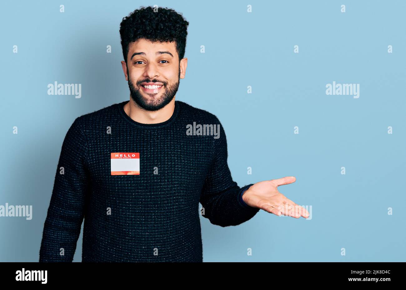 Young arab man with beard wearing hello my name is sticker ...