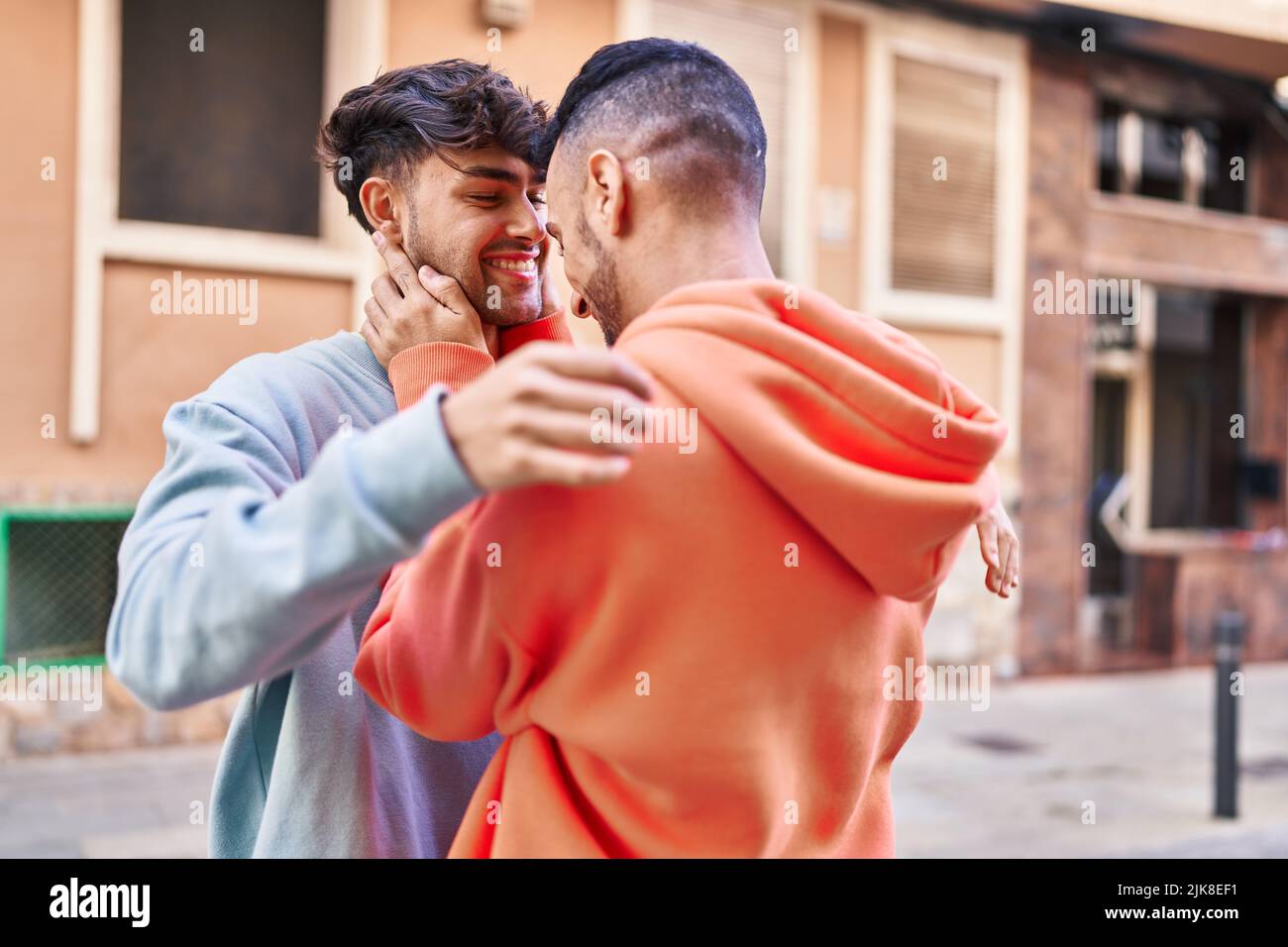 Two man couple hugging each other standing at street Stock Photo - Alamy
