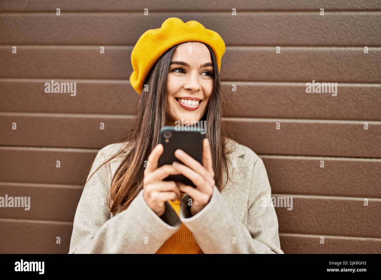 Young hispanic girl smiling happy using smartphone at the city Stock ...