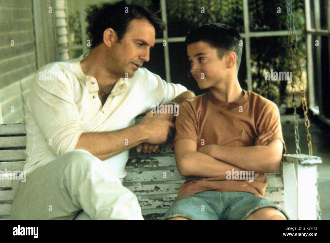 Kevin Costner & Elijah Wood  Film The War (1994) Characters: Stephen Simmons & Stu Simmons  Director: Jon Avnet 04 November 1994   **WARNING** This Photograph is for editorial use only and is the copyright of UNIVERSAL and/or the Photographer assigned by the  Film or Production Company and can only be reproduced by publications in conjunction with the promotion of the above  Film. A Mandatory Credit To UNIVERSAL is required. The Photographer should also be credited when known. No commercial use can be granted without written authority from the  Film Company. Stock Photo