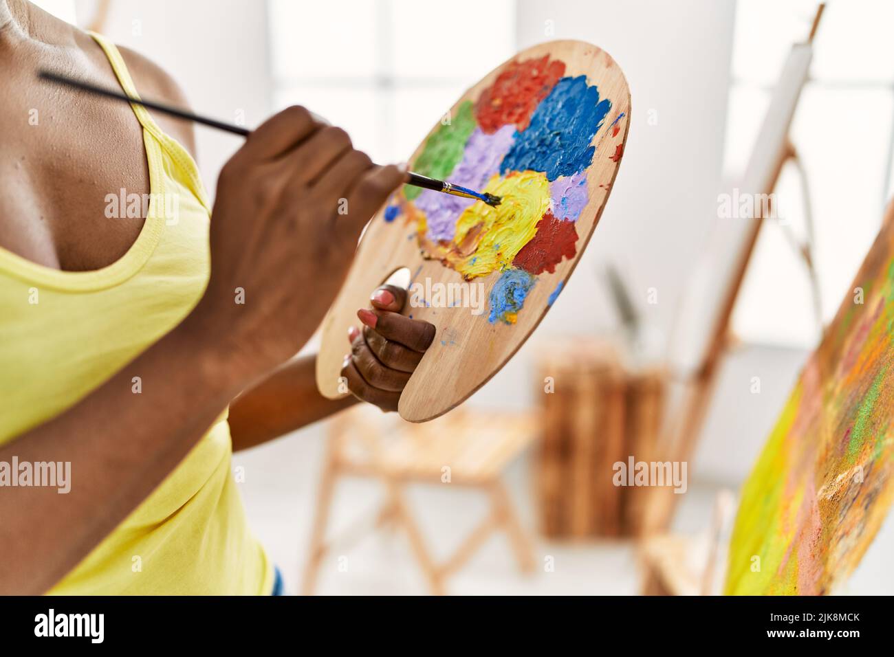 African american artist woman mixing color on palette at art studio. Stock Photo