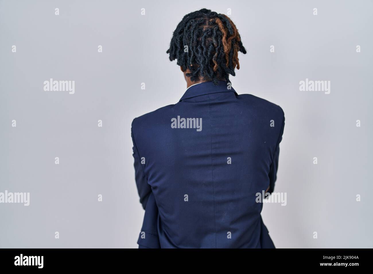Young african man with dreadlocks wearing business jacket over white ...