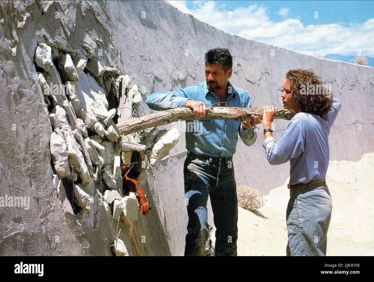 Fred Ward & Finn Carter Film: Tremors (USA 1990) Characters: Earl Bassett, Rhonda LeBeck  / Titel Auch: 'Im Land Der Raketen-Würmer' Director: Ron Underwood 19 January 1990   **WARNING** This Photograph is for editorial use only and is the copyright of UNIVERSAL PICTURES and/or the Photographer assigned by the Film or Production Company and can only be reproduced by publications in conjunction with the promotion of the above Film. A Mandatory Credit To UNIVERSAL PICTURES is required. The Photographer should also be credited when known. No commercial use can be granted without written authority Stock Photo