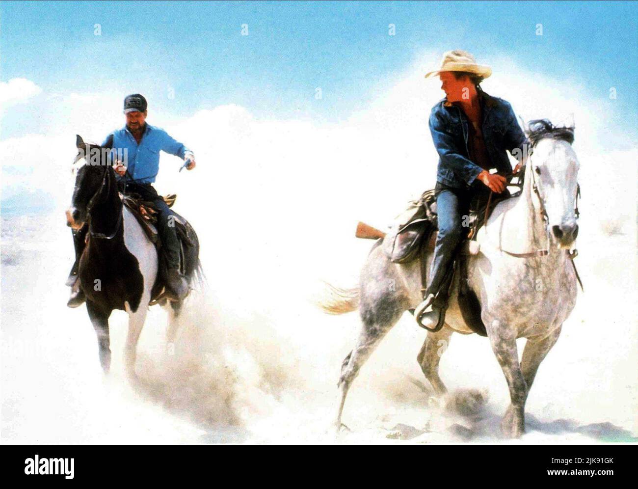 Fred Ward & Kevin Bacon Film: Tremors (USA 1990) Characters: Earl Bassett, Valentine McKee  / Titel Auch: 'Im Land Der Raketen-Würmer' Director: Ron Underwood 19 January 1990   **WARNING** This Photograph is for editorial use only and is the copyright of UNIVERSAL PICTURES and/or the Photographer assigned by the Film or Production Company and can only be reproduced by publications in conjunction with the promotion of the above Film. A Mandatory Credit To UNIVERSAL PICTURES is required. The Photographer should also be credited when known. No commercial use can be granted without written authori Stock Photo