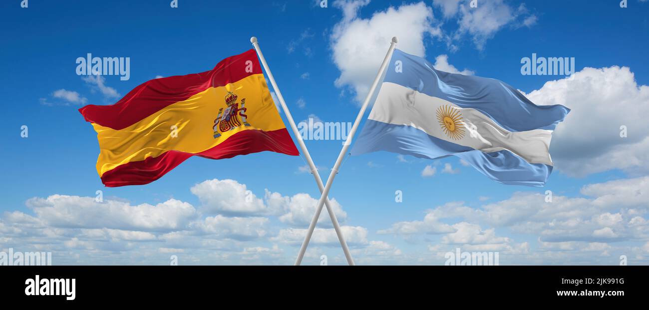 two crossed flags Argentina and spain waving in wind at cloudy sky ...