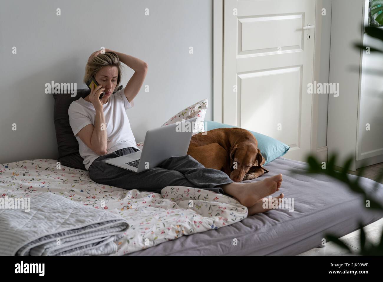 Busy middleaged woman talks on smartphone with important person
