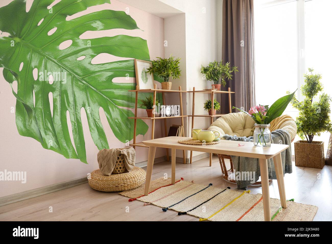 Beautiful interior of modern stylish room with print of monstera leaf ...